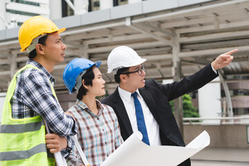 Asian contractor and engineer inspecting material in construction building.