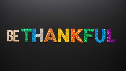 be thankful word lettering made of colorful glitter shining effect on plain black background
