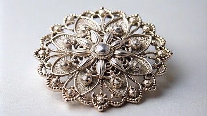 Fototapeta premium Elegant silver brooch with intricate details on white background