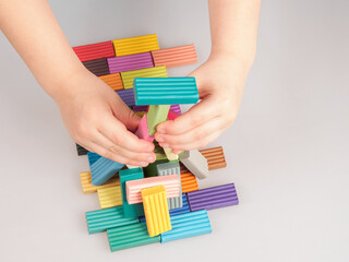 The child enthusiastically plays with plasticine, forming bright figures, developing creative skills and fine motor skills