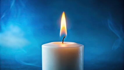 Extreme close-up of burning white candle on blue background