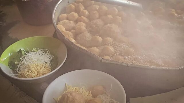 cooking and show of making bakso or meatballs, preparing bakso beef meatball, view of a bakso vendor preparing meatball dish for the buyer