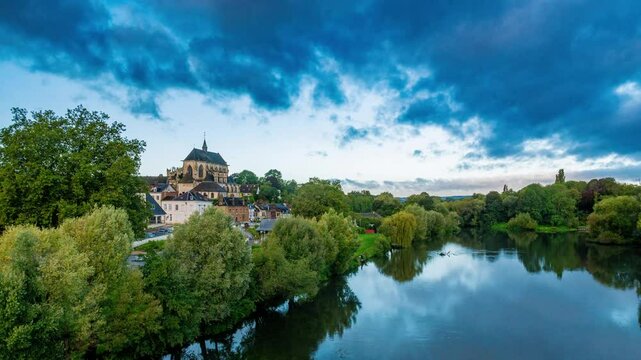 a timelapse of clouds lifting from this rural village in Normandy in the morning, over a medieval church