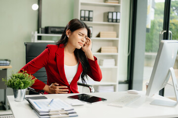Overworked young Asian businesswoman office worker suffering from neck pain after had a long day