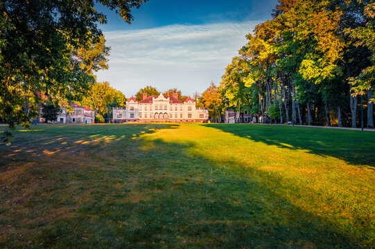 Exciting evening view of green meadow, foliage trees and Rokiskis castle on background. Splendid summer cityscape of Rokiskis town, Latvia, Europe. Traveling concept background.