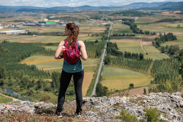Naklejka premium Young woman enjoying nature.Hiking in the mountains, observing the landscape.Doing sports and physical activity.Let's take care of our natural surroundings and our environment.Moments of disconnection