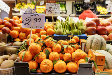 View at the market stalls with vegetables and fruits. A lot of oranges layins. Food and shopping concept. Stock photo