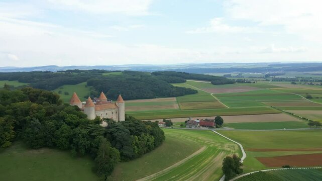 Push in drone shot of Champvent Castle with the woods behind in Canton of Vaud in Switzerland.