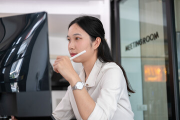 Woman examines stock graphs in tablet and computer