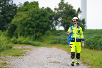 Windturbine inspector wearing Personal protective equipment working at wind turbines farm