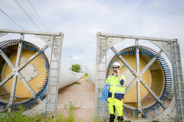 Windturbine inspector wearing Personal protective equipment working at wind turbines farm