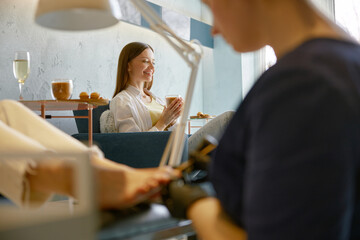 Young woman friends gossiping whispering secrets at nail studio