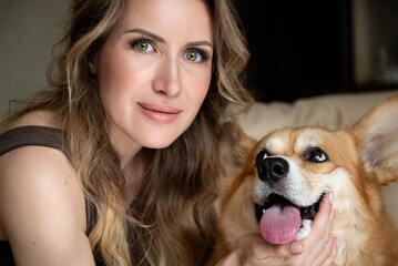 portrait of young attractive blonde hair woman with her ginger corgi dog