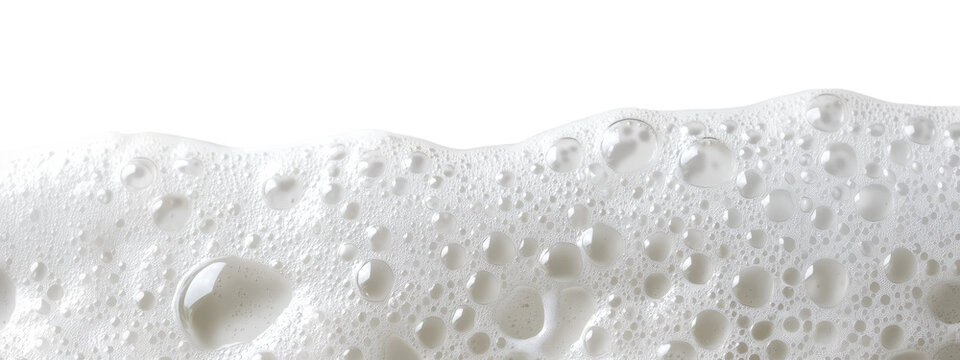 Close-up of white soap bubbles with water droplets on transparent background captured in a bright setting
