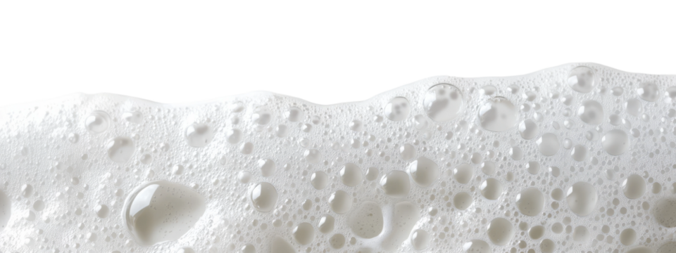 Close-up of white soap bubbles with water droplets on transparent background captured in a bright setting