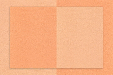 Fototapeta premium Texture of peach fuzz and coral paper background with geometric shape, macro. Structure of craft cardboard