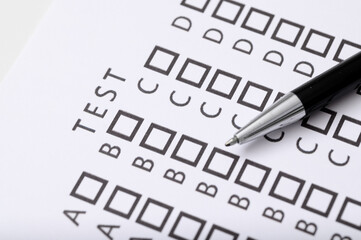 Test wyboru, długopis leży na karcie z odpowiedziami A B C D , Test wiedzy 