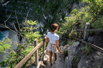 Woman walking down the hectic path at Kelingking Beach, Nusa Penida