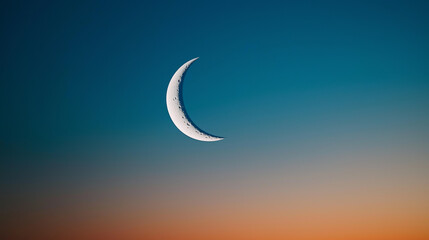Obraz premium Crescent Moon Hanging Low Above the Horizon at Dusk