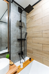 This elegantly designed bathroom features a spacious bathtub, a modern sink, a charming framed mirror, and a thoughtfully designed separate shower stall for comfort and convenience