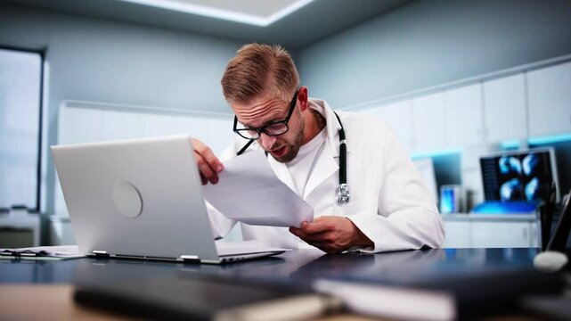 Shocked Medical Doctor Reading Document At Desk