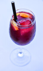 Cold cocktail with ice, sangria, glass with straw