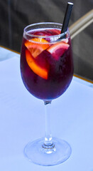 Cold cocktail with ice, sangria, glass with straw