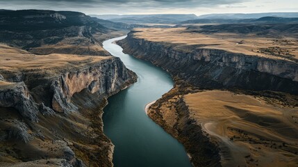 A stunning aerial view of a winding river carving through a rugged landscape, showcasing dramatic cliffs and serene nature.