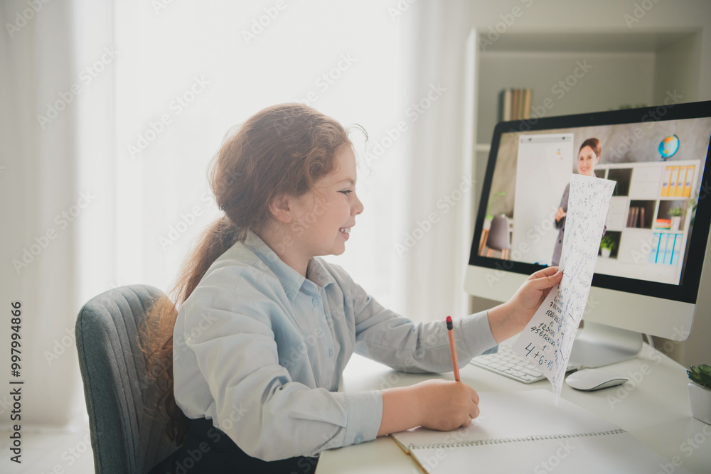 Canvas Prints Photo of clever smart girl schoolkid learner sitting chair desk studying from home doing homework read test daylight indoors