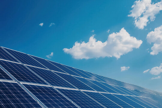 A solar panel is on a roof with a blue sky and clouds in the background