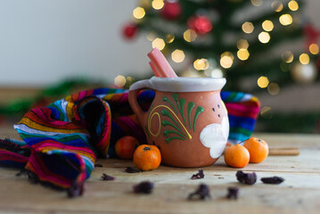 Typical Mexican Christmas punch on wooden table with Christmas tree in the background.