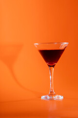 wine in a glass isolated on warm orange background
