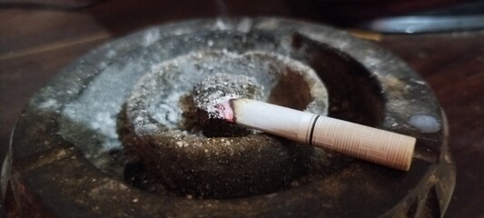 a lit cigarette on an ashtray