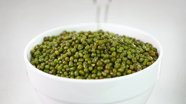 Filling green moong dal in a bowl.
