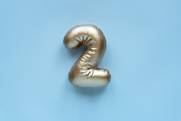 golden number 2 on a light background
