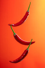 pile of red chili peppers isolated on warm orange background