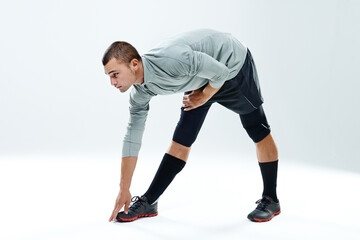 Obraz premium Fitness, man and stretching legs in studio for body wellness, warm up exercise or getting ready for workout. Athlete, person or flexible on white background mockup with training, preparing or balance