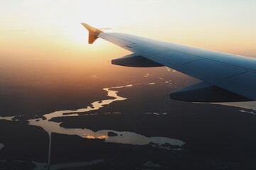 wing of airplane above blue clouds