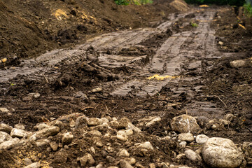 Traces from a passing tractor on the damp ground. Wheel tracks on the ground