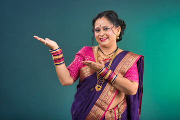 Cheerful Indian traditional woman presenting something, showing copy space on her palm