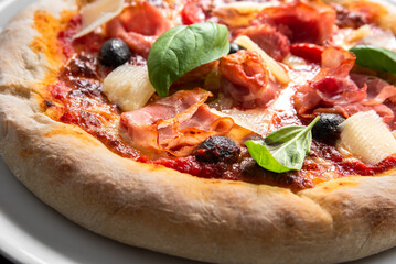 Deliziosa pizza italiana condita con prosciutto, olive nere e parmigiano, gastronomia europea 