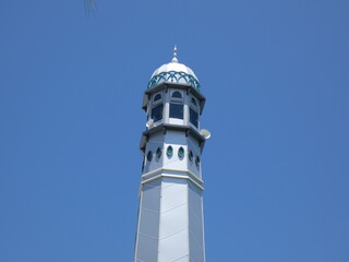 Muslim mosque. Mosque minaret with copper-covered dome against azure sky. emblematic of Ramadan and Islam.