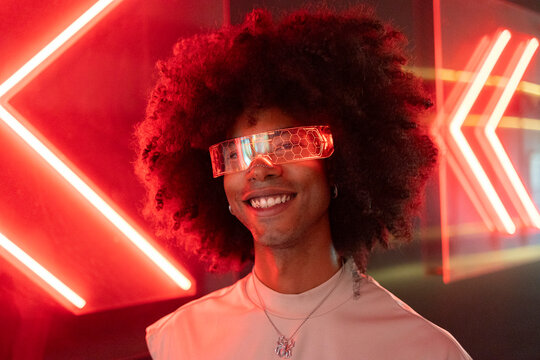 Smiling young man wearing illuminated smart glasses