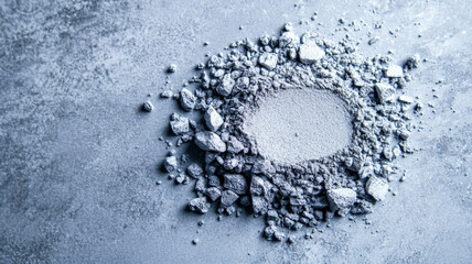 Frosty silver eyeshadow powder finely scattered on a cool grey surface resembling a winter frost pattern 