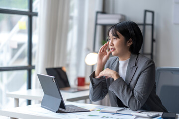 Businesswoman having video call on tablet and gesturing in modern office