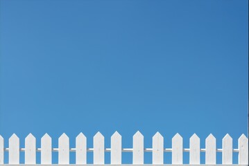 Fototapeta premium White picket fence against a clear blue sky