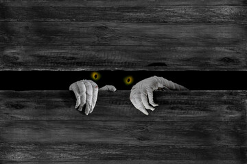 Mummy's hands wrapped in bandage rises through wooden boards. Background with copy space. Horrible...