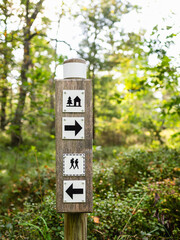 Wooden sign directing travelers to the youth hostel in a serene forest setting in Sweden, ideal for adventurers exploring nature