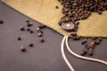 Black pepper scattered on a black background closeup