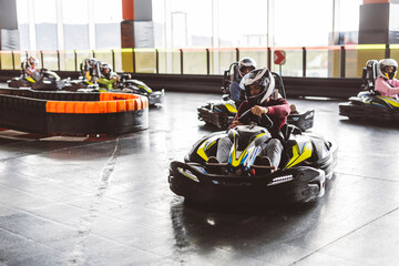 Go-Kart Racers Turning Corner on Indoor Track